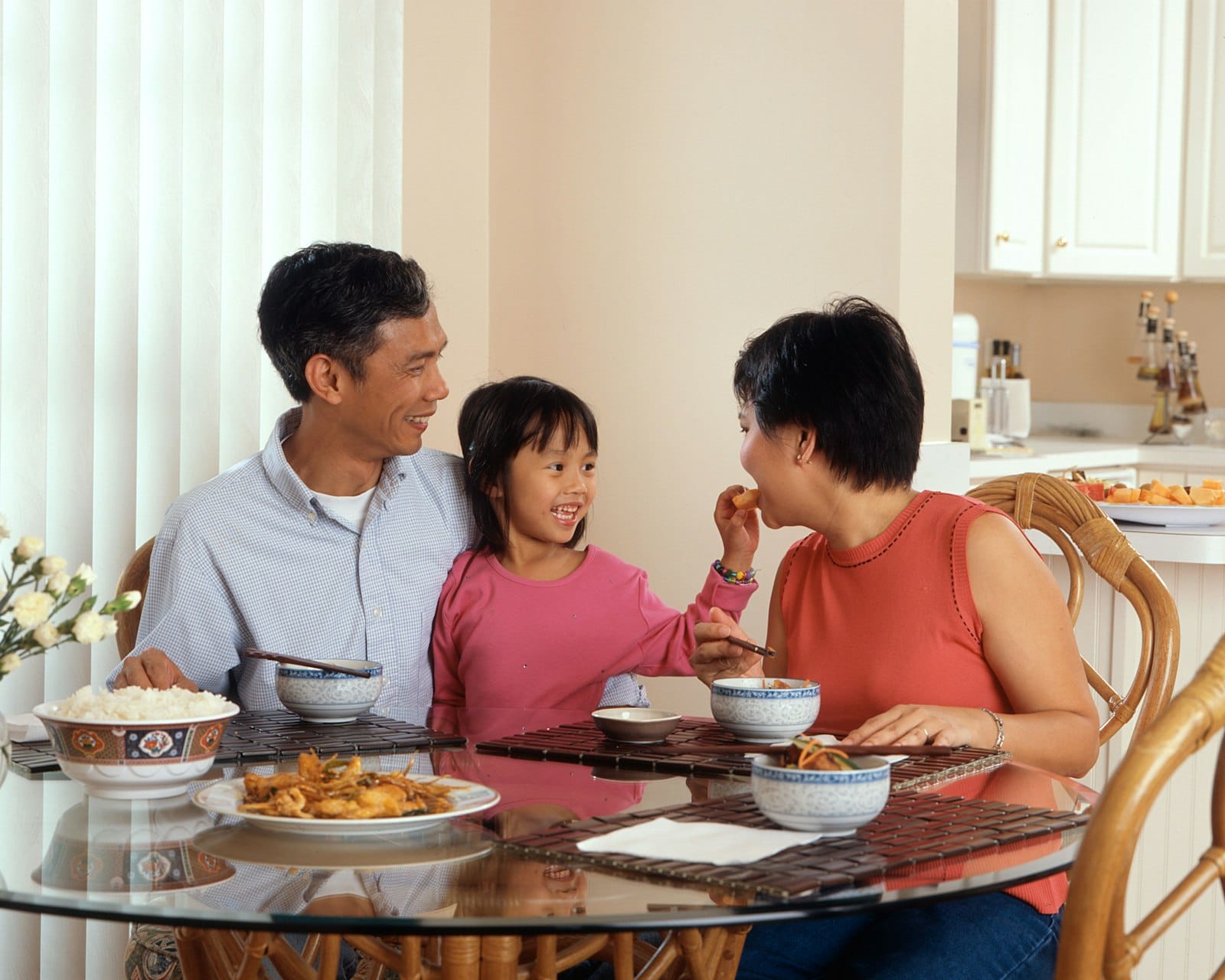 Parents and their young daughter sharing a meal at home, representing family counselling